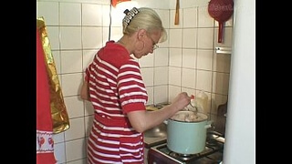 Старуха со светлыми волосами варит суп на кухне и занимается фистингом с сожителем
