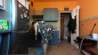 Толстая женщина с обвисшими дойками протирает пол на кухне и светит голой грудью
